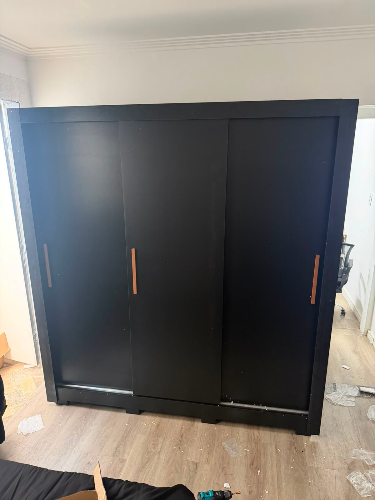 Guarda-roupa preto de portas de correr durante serviço de desmontagem de móveis