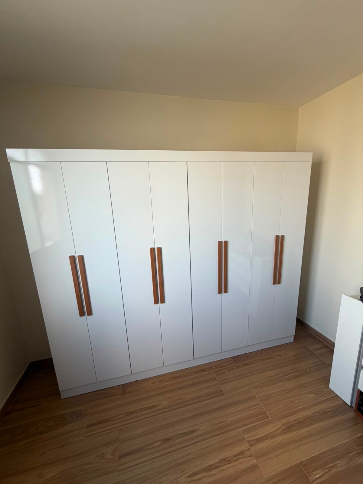 Guarda-roupa branco de oito portas montado em quarto